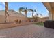 Paved backyard featuring palm trees and a built-in barbecue at 22837 E Silver Creek Ln, Queen Creek, AZ 85142