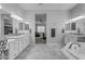 Luxurious bathroom featuring a soaking tub, double sinks, and modern lighting fixtures at 22837 E Silver Creek Ln, Queen Creek, AZ 85142