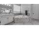 Bright bathroom with a corner soaking tub, white countertops, and modern lighting fixtures at 22837 E Silver Creek Ln, Queen Creek, AZ 85142