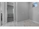 An empty bedroom with grey walls, white tiling, and carpeted room within view at 22837 E Silver Creek Ln, Queen Creek, AZ 85142