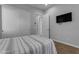 Comfortable bedroom featuring a striped bed, a television, and plenty of closet space at 22837 E Silver Creek Ln, Queen Creek, AZ 85142