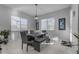 Formal dining room with large windows, modern chandelier, tile flooring, and seating for six at 22837 E Silver Creek Ln, Queen Creek, AZ 85142