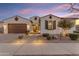 Charming single-story home with a two-car garage, desert landscaping, and a welcoming entrance at dusk at 22837 E Silver Creek Ln, Queen Creek, AZ 85142