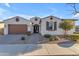 Inviting home featuring desert landscaping, two-car garage, and warm curb appeal with a paved walkway to the front door at 22837 E Silver Creek Ln, Queen Creek, AZ 85142