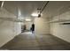 Spacious garage interior featuring concrete floor, shelving, and ample room for storage at 22837 E Silver Creek Ln, Queen Creek, AZ 85142