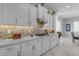 Elegant kitchen with white cabinets, mosaic backsplash, and modern appliances at 22837 E Silver Creek Ln, Queen Creek, AZ 85142