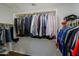 Walk-in closet featuring multiple hanging rods and a variety of clothing at 2527 W Amber Sun Dr, Phoenix, AZ 85085