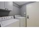 The laundry room has a washer, dryer, cabinets, and white door inside this home at 2527 W Amber Sun Dr, Phoenix, AZ 85085