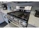 Close-up of stainless-steel stove with granite countertop and grey cabinets at 2527 W Amber Sun Dr, Phoenix, AZ 85085