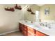 Bright bathroom with double sinks, a large mirror, and decorative shelves at 26826 N 66Th Ln, Phoenix, AZ 85083