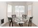 Bright dining area with large windows, a modern chandelier, and a stylish table set for four at 26826 N 66Th Ln, Phoenix, AZ 85083