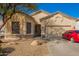 Charming single-story home with a two-car garage and mature landscaping, complemented by a red car in the driveway at 26826 N 66Th Ln, Phoenix, AZ 85083