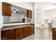 Cozy kitchen featuring wood cabinets, sleek countertops, tile flooring and an open view into the living space at 26826 N 66Th Ln, Phoenix, AZ 85083