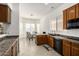 Sunlit kitchen showcases wood cabinets, a sleek black sink, tile flooring, and a charming breakfast nook at 26826 N 66Th Ln, Phoenix, AZ 85083