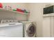 Functional laundry room with a washer, dryer, and shelving for storage at 26826 N 66Th Ln, Phoenix, AZ 85083