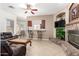 Comfortable living room area featuring a stone fireplace, TV, and seamless flow into the dining area at 26826 N 66Th Ln, Phoenix, AZ 85083