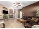 Inviting living room with a stone fireplace, comfortable leather sofa and tiled floors at 26826 N 66Th Ln, Phoenix, AZ 85083