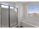 Bright bathroom featuring a glass shower and a soaking tub under the window at 3316 E Kingbird Pl, Chandler, AZ 85286