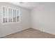 Empty bright bedroom with plantation shutters, carpeted floor, and light-colored walls at 3316 E Kingbird Pl, Chandler, AZ 85286