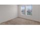 Neutral bedroom featuring two windows with blinds, carpet flooring, and ample natural light at 3316 E Kingbird Pl, Chandler, AZ 85286