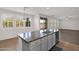 Kitchen island with granite countertop, stainless steel sink, and white cabinets under bright lighting at 3316 E Kingbird Pl, Chandler, AZ 85286