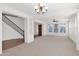 Spacious living room featuring neutral carpet, white walls, a ceiling fan, staircase and lots of natural light at 3316 E Kingbird Pl, Chandler, AZ 85286