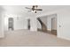 Bright living room with neutral carpet, white walls, and an archway that gives way to the entry of the home with staircase at 3316 E Kingbird Pl, Chandler, AZ 85286