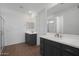 An ensuite bathroom features double sinks, gray cabinetry and a large mirror at 34464 N Timberlake N Mnr, San Tan Valley, AZ 85144