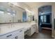 Well-lit bathroom with double sinks, modern fixtures, and a peek into the main bedroom at 35307 N Agua Caliente --, San Tan Valley, AZ 85144