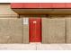 View of a vibrant red gate entrance within a tan stucco wall, warning sign posted at 355 E Thomas Rd # B110, Phoenix, AZ 85012