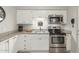 Modern kitchen featuring granite counters, white cabinets, and stainless steel appliances at 355 E Thomas Rd # B110, Phoenix, AZ 85012