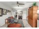 Inviting living room featuring a ceiling fan, gray sofa, ottoman, and a wooden cabinet for a comfortable and stylish space at 355 E Thomas Rd # B110, Phoenix, AZ 85012