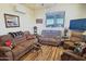 Comfortable living room features cozy seating, wood floors, and a bright window at 35524 N 215Th Dr, Wittmann, AZ 85361
