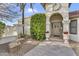 Inviting front entrance with decorative planters and a stone bench, framed by a lush green shrub and stucco walls at 4010 E Grandview St, Mesa, AZ 85205
