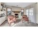 Cozy living room features a tiled fireplace, two armchairs, a window, and neutral carpet at 4010 E Grandview St, Mesa, AZ 85205
