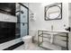 Modern bathroom featuring sleek fixtures, a glass shower door, and black tile accents at 4219 N 41St Pl, Phoenix, AZ 85018