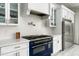 Modern kitchen with white cabinets, a blue range, quartz countertops, and stainless steel fridge at 4219 N 41St Pl, Phoenix, AZ 85018