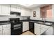 Functional kitchen featuring white cabinets, black appliances, and ample counter space at 4303 E Cactus Rd # 408, Phoenix, AZ 85032