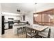 Open kitchen featuring white cabinets, black appliances, and a cozy dining area at 4303 E Cactus Rd # 408, Phoenix, AZ 85032
