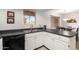 Well-lit kitchen with modern stainless steel sink, white cabinets, and black countertops at 4303 E Cactus Rd # 408, Phoenix, AZ 85032