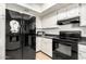 Efficient kitchen with stainless steel refrigerator, black appliances, and white cabinetry at 4303 E Cactus Rd # 408, Phoenix, AZ 85032
