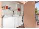 Indoor laundry area with full-size washer and dryer, storage shelves, and door to outdoor space at 4303 E Cactus Rd # 408, Phoenix, AZ 85032