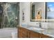 Modern bathroom boasts a sleek vanity, illuminated mirror, and luxurious marble wall detail at 4900 E Arroyo Verde Dr, Paradise Valley, AZ 85253