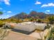 Aerial view of modern home with desert landscaping, driveway and three-car garage, and mountain backdrop at 4900 E Arroyo Verde Dr, Paradise Valley, AZ 85253