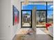 Modern foyer with colorful art, stylish rug and view to the exterior through glass doors at 4900 E Arroyo Verde Dr, Paradise Valley, AZ 85253