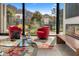 Stylish living room with comfortable red chairs, fireplace and expansive windows with mountain views at 4900 E Arroyo Verde Dr, Paradise Valley, AZ 85253