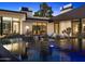 Modern home reflecting in the luxurious pool with desert landscape and chic outdoor furniture at 4900 E Arroyo Verde Dr, Paradise Valley, AZ 85253