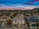 Aerial view of the home at dusk with a desert landscaped backyard, pool, patio and mountain views at 5323 E Thunder Hawk E Rd, Cave Creek, AZ 85331
