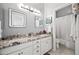 Bright bathroom featuring double vanities, granite countertops, white cabinets, decorative mirrors and a shower-tub combo at 5323 E Thunder Hawk E Rd, Cave Creek, AZ 85331