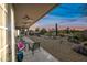 Covered patio with outdoor seating area and ceiling fans overlooking the manicured desert landscaped backyard at 5323 E Thunder Hawk E Rd, Cave Creek, AZ 85331